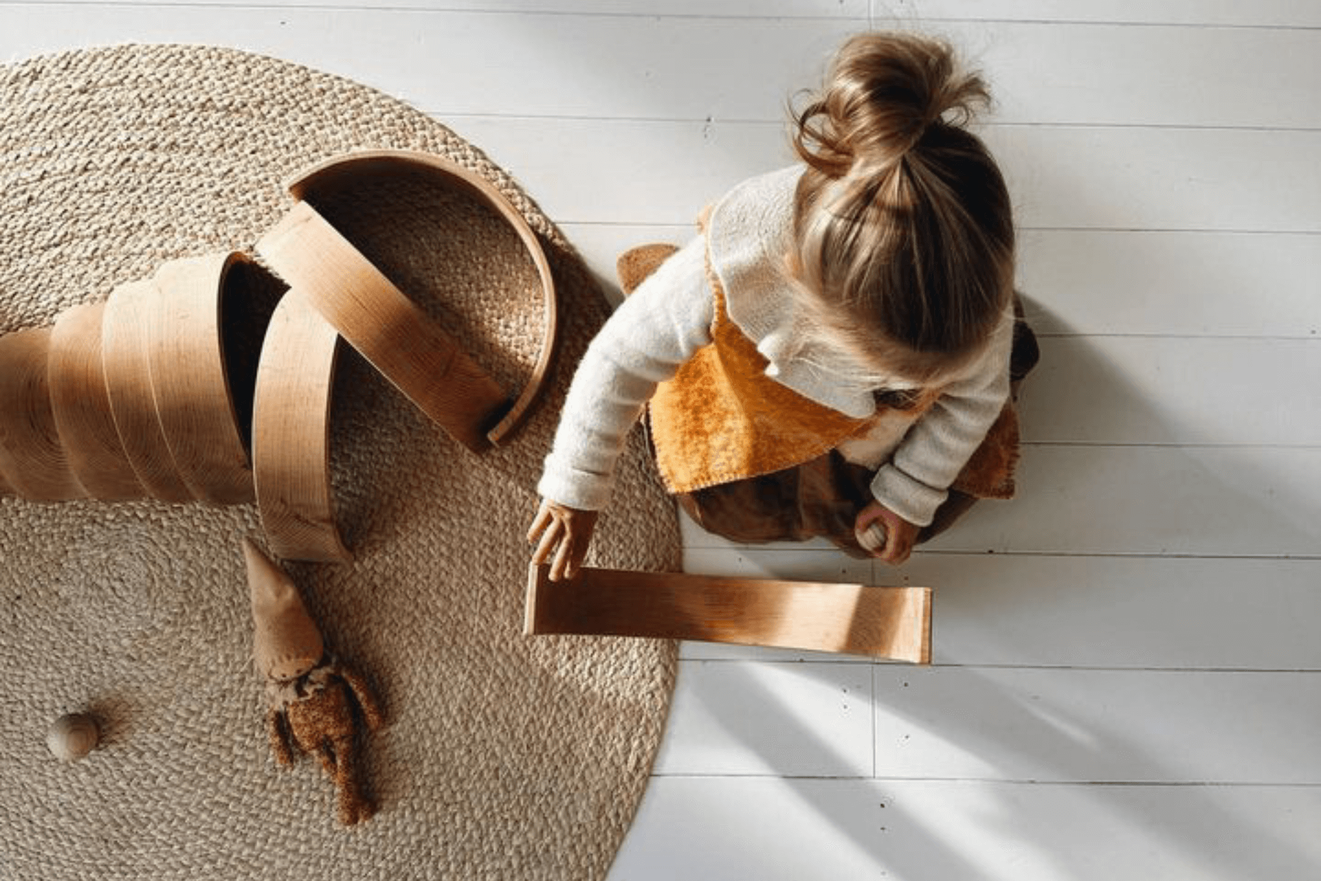 Top view of a toddler with wooden toys